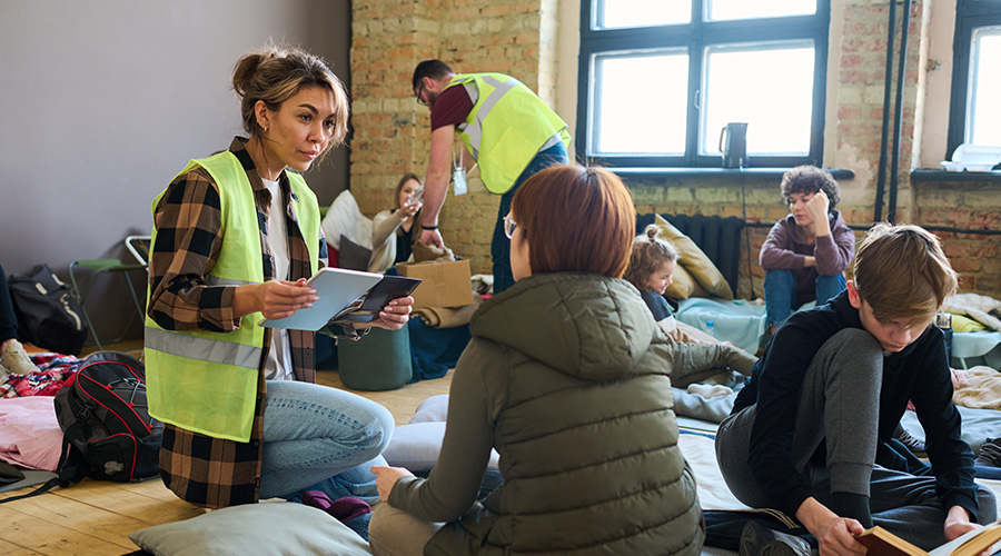 woman talking to refugees at shelter