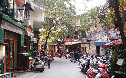 Street scene in Hanoi’s Old Quarter showing narrow roads and motorbikes, where tunneling for Metro Line 2 faces tight clearances and heritage-site challenges.
