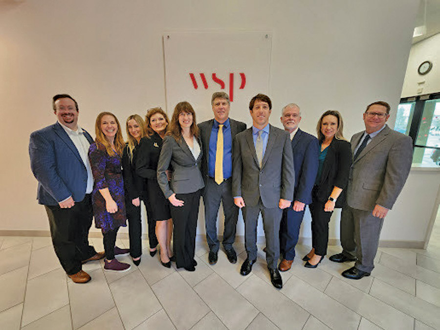 Group photo of Helminski's team in front of a WSP banner